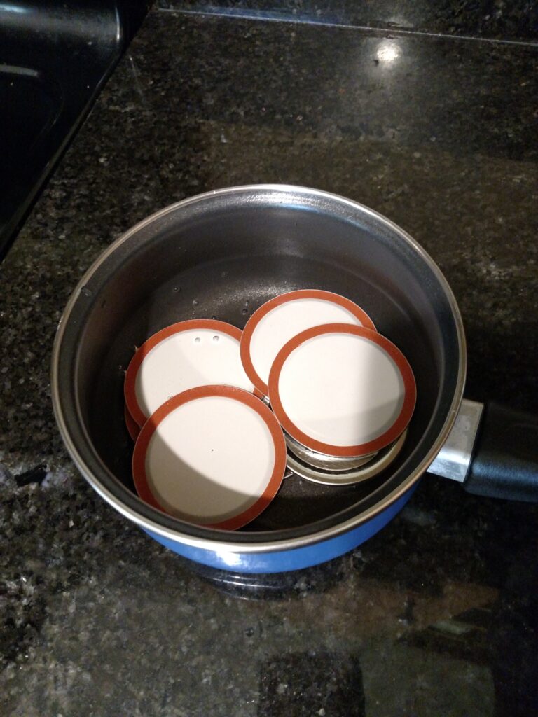 a small pan of water with canning lids in it to warm