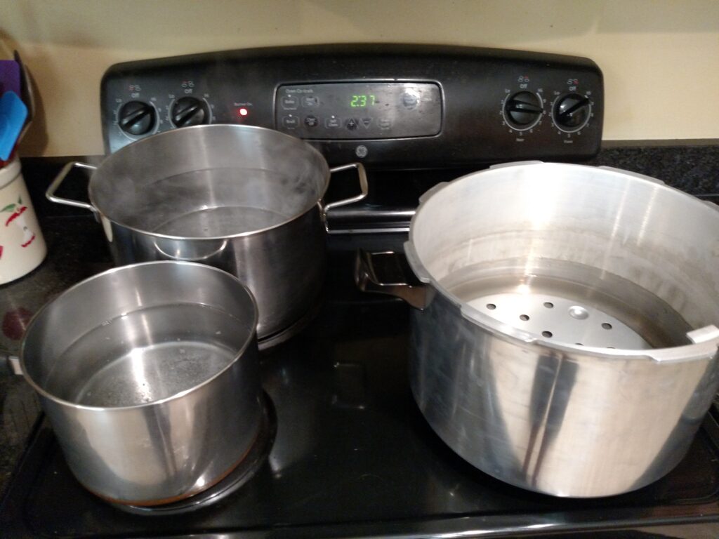 3 pots on the stove to can green beans
