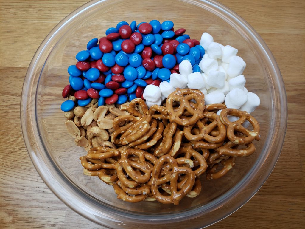 patriotic trail mix ingredients in a bowl before mixing them together