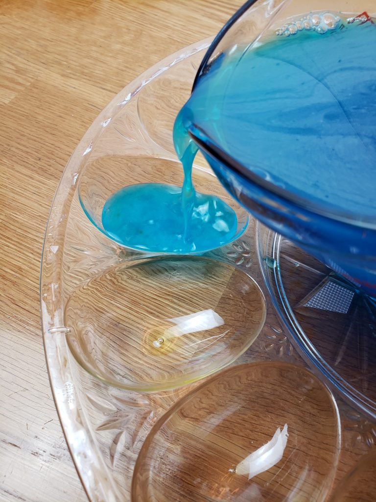 pouring blue Jell-O into deviled egg containers