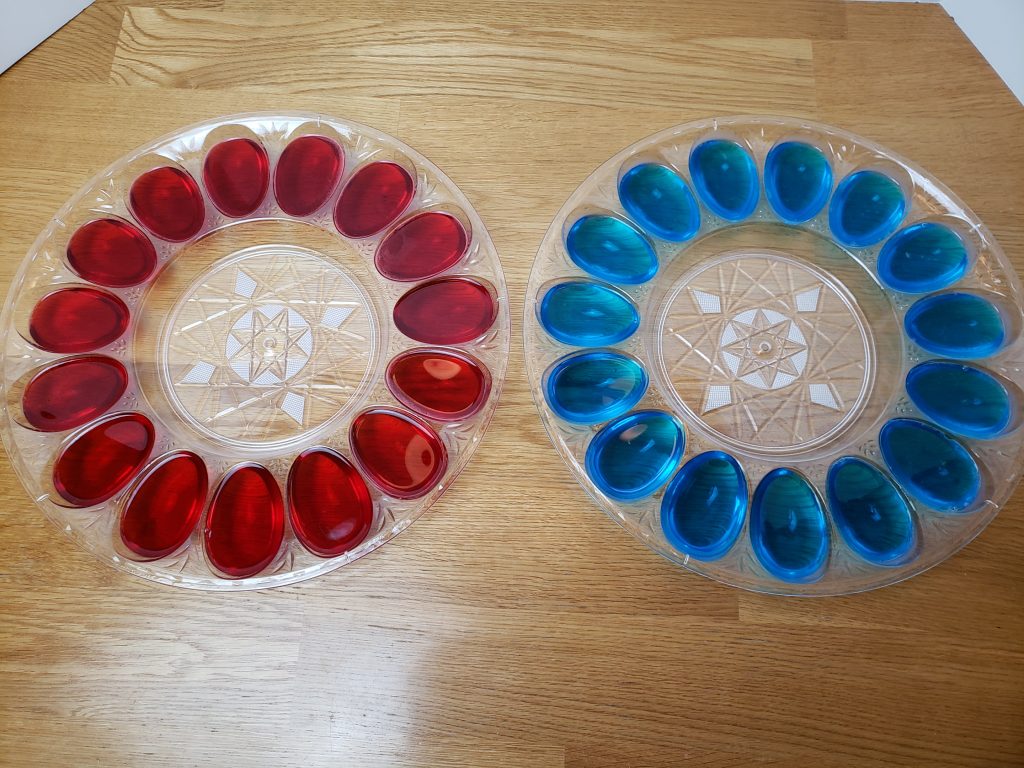 2 deviled egg containers with Jell-O. One is red and one is blue.