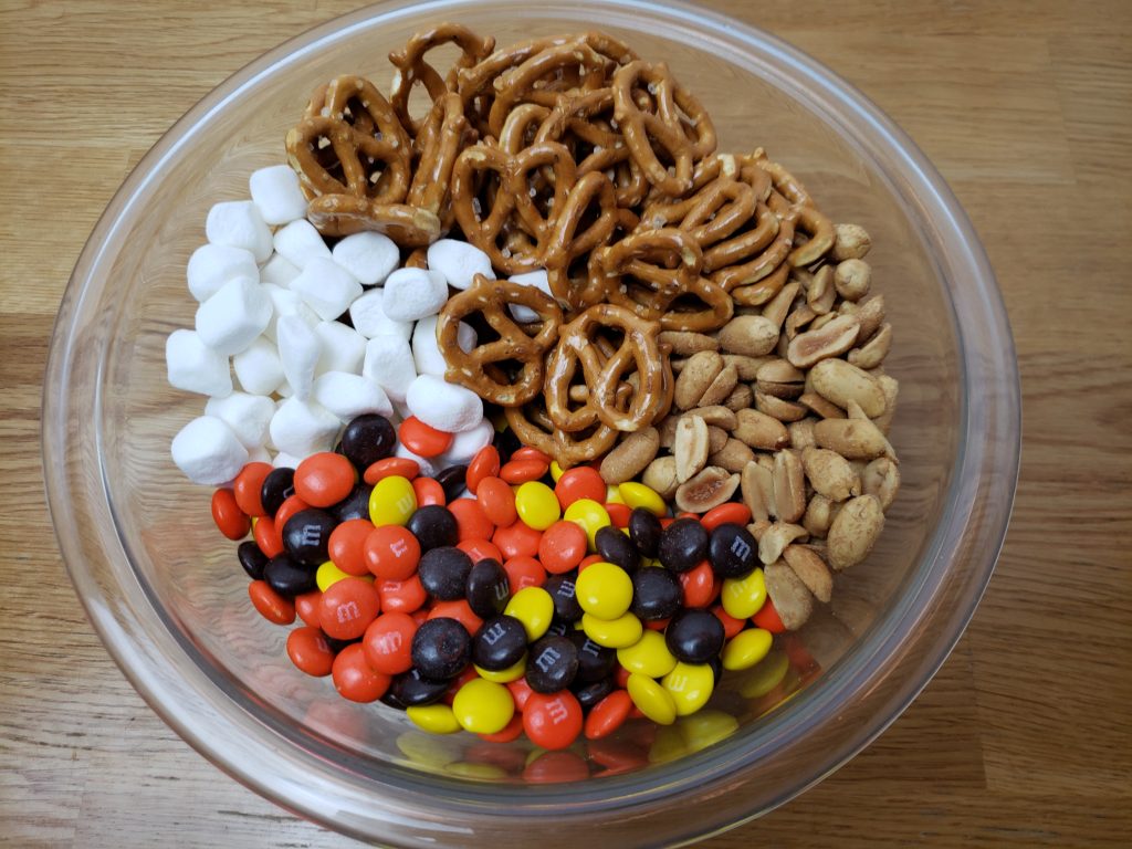 ingredients for fall halloween trail mix in glass bowl