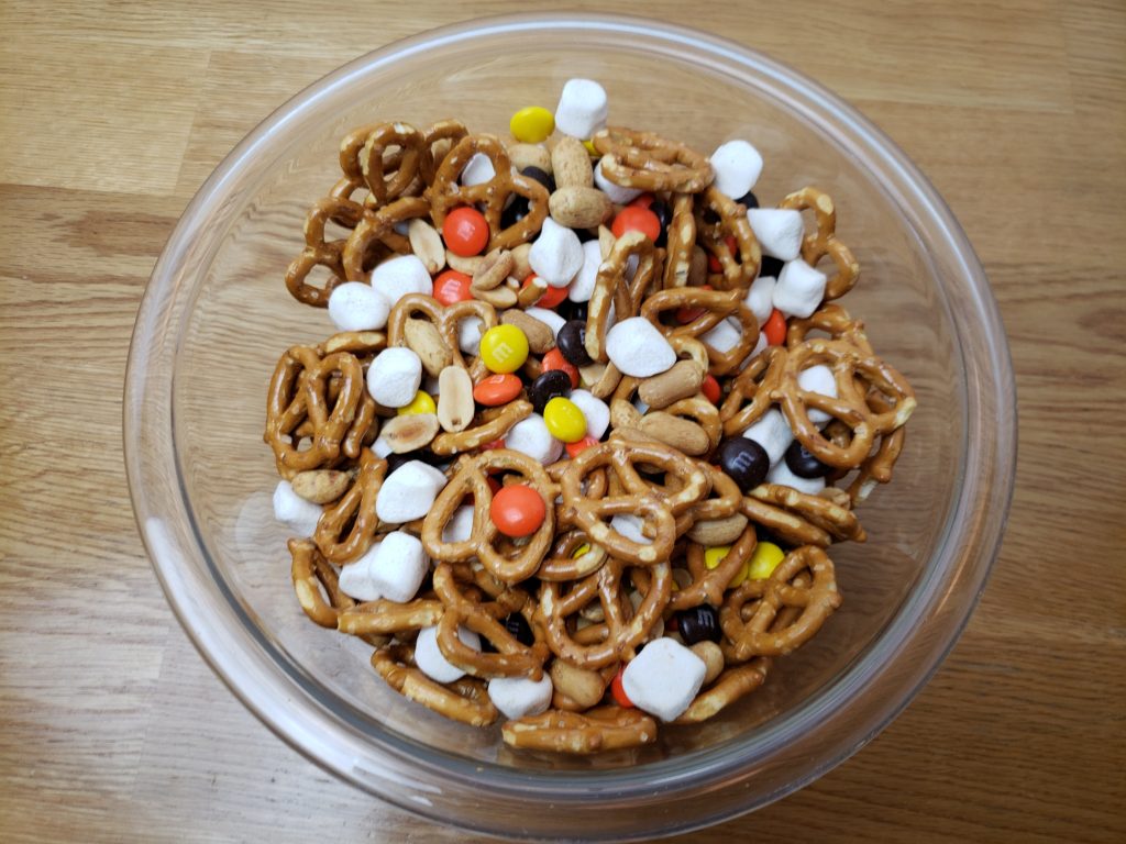 ingredients for fall halloween trail mix mixed in bowl