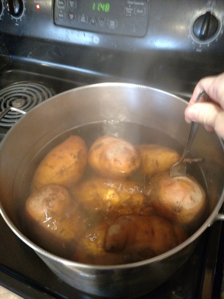 testing sweet potatoes for done-ness with fork