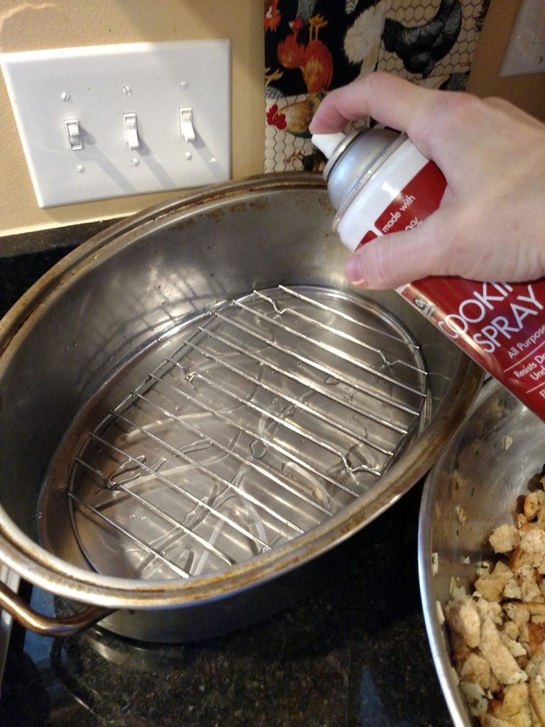 spraying turkey pan with cooking spray