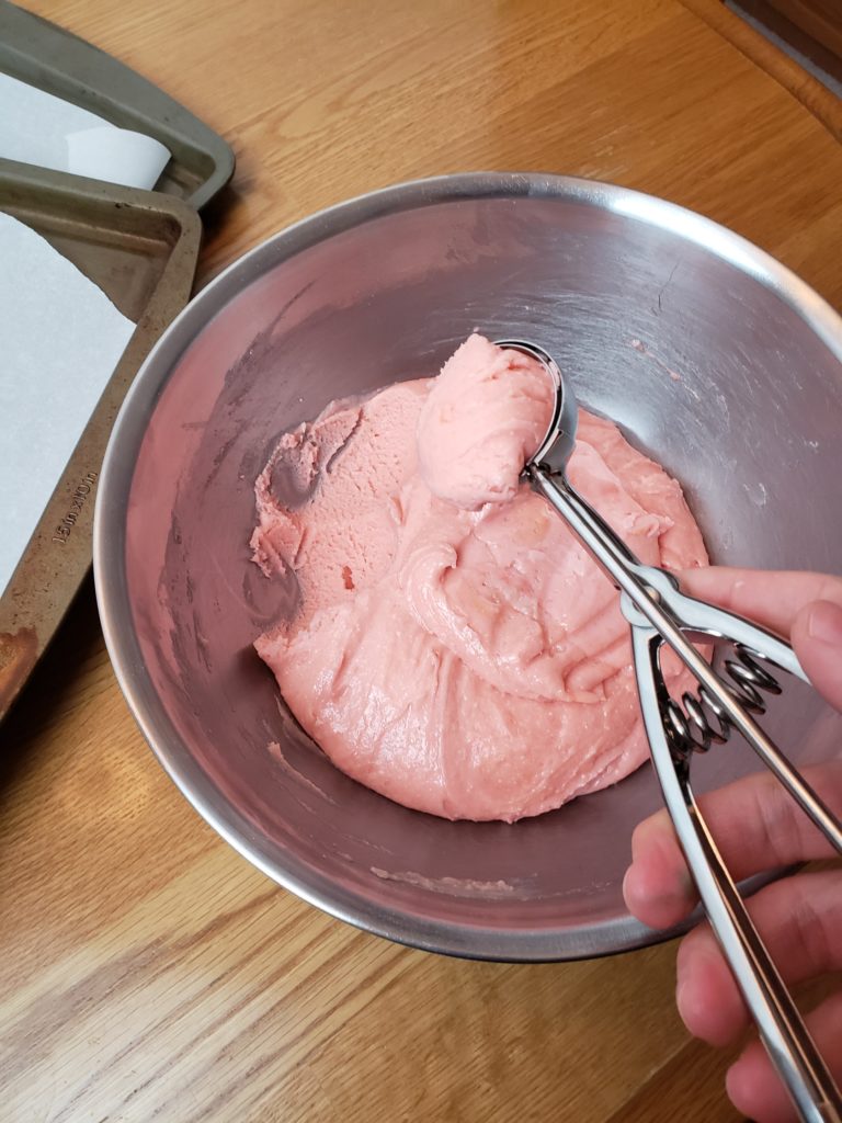 scooping out pink cookie dough