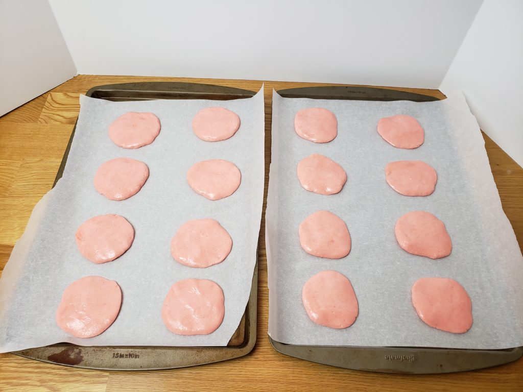 pink cookies on cookie sheet unbaked