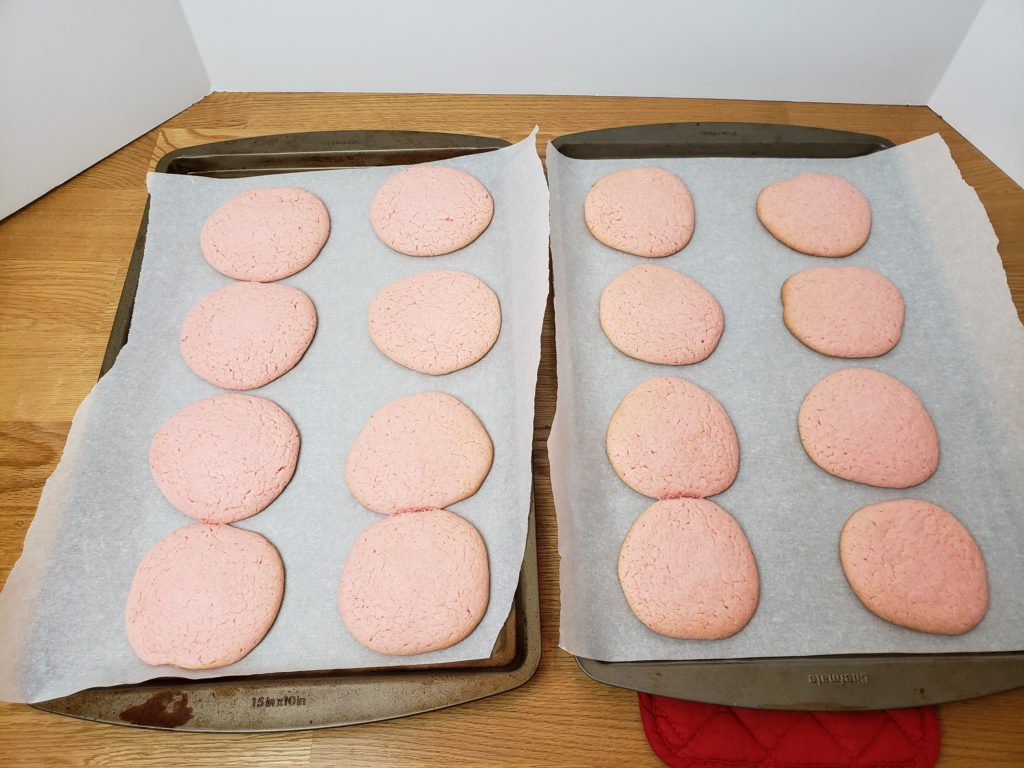 pink cookies on cookie sheet baked