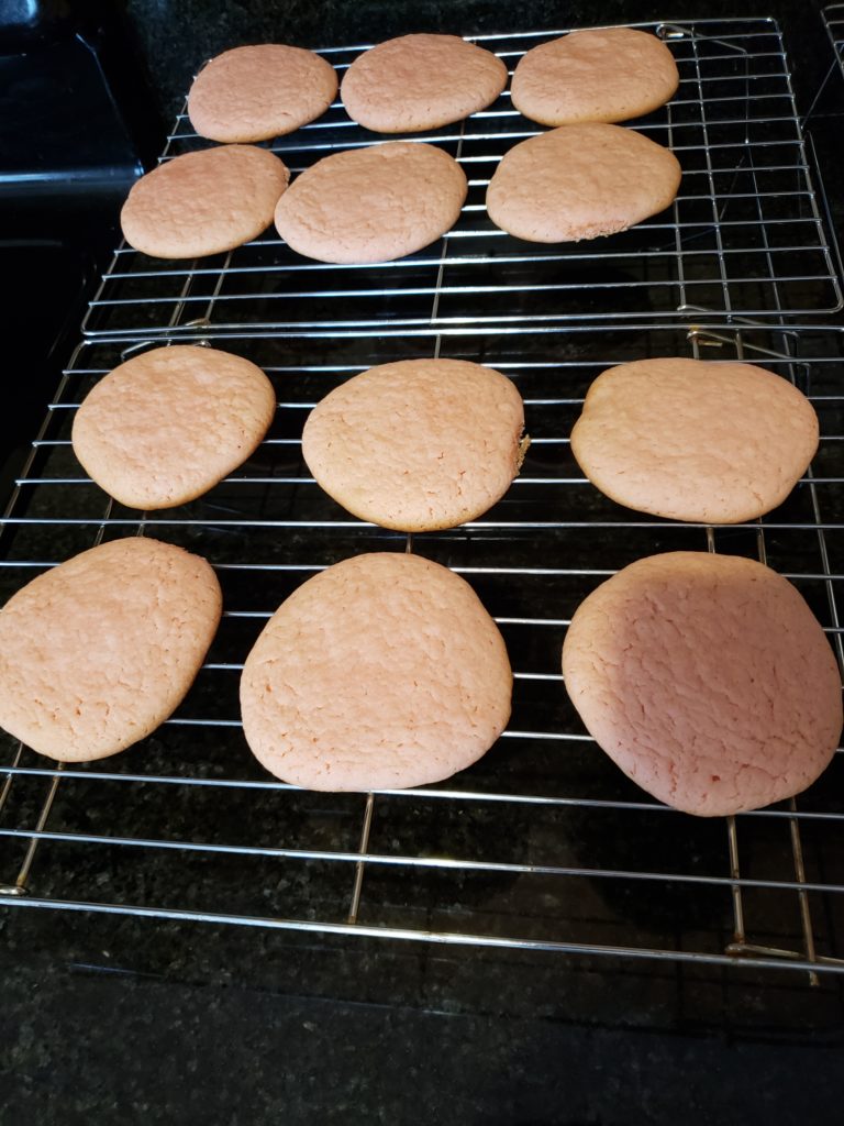 pink cookies on wire cooling rack