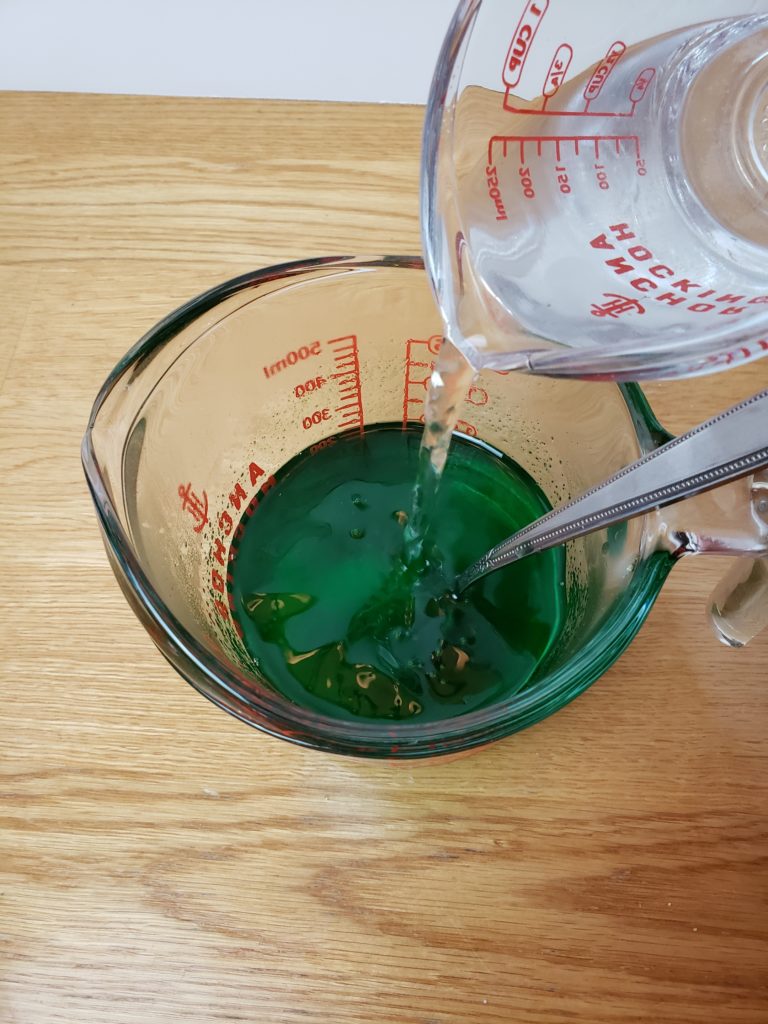 pouring water into green jello