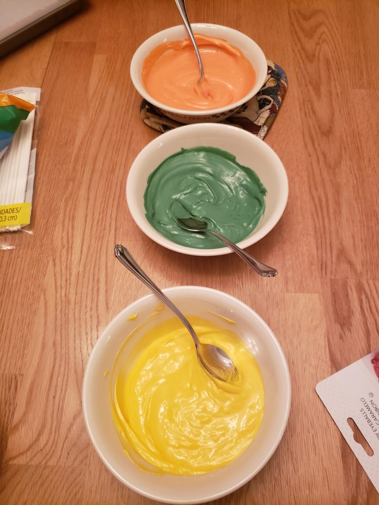 3 bowls of melted candy melts; orange, green and yellow