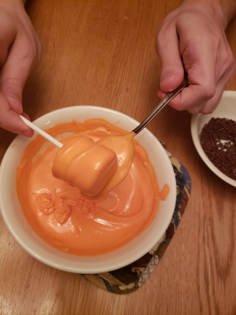 covering marshmallow with orange candy coating