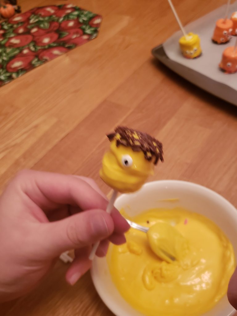 a yellow Halloween Monster Marshmallow Pop with one eye and brown sprinkles for hair