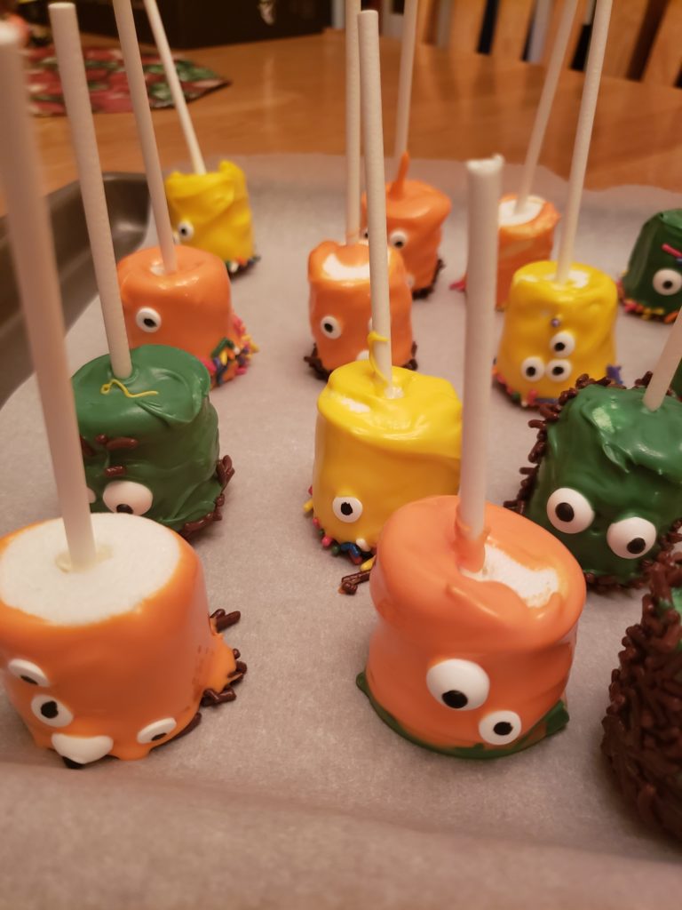 Halloween Monster Marshmallow Pops drying on parchment paper