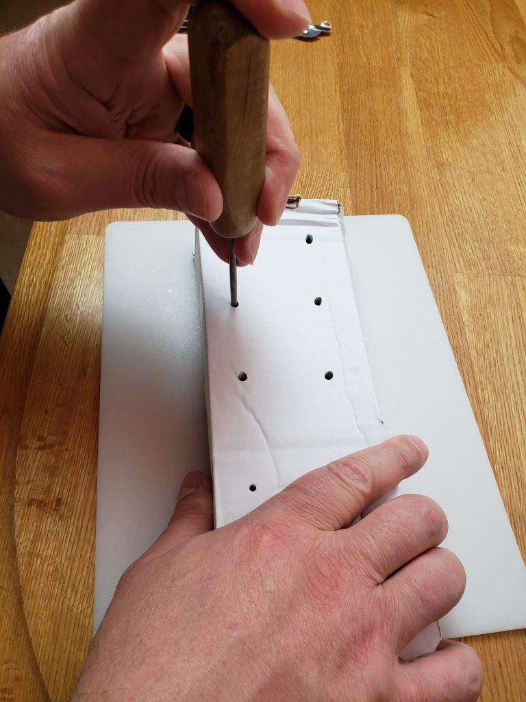 punching holes in the drying rack