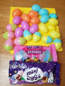 plastic colored Easter eggs and candy laid out to fill