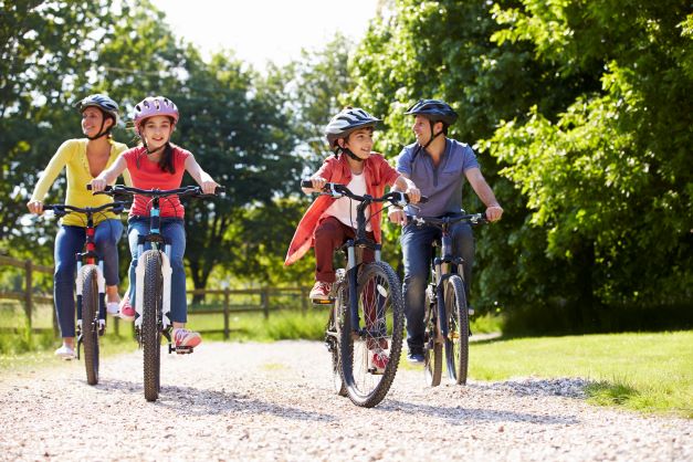 family of 4 people riding bikes on stone road