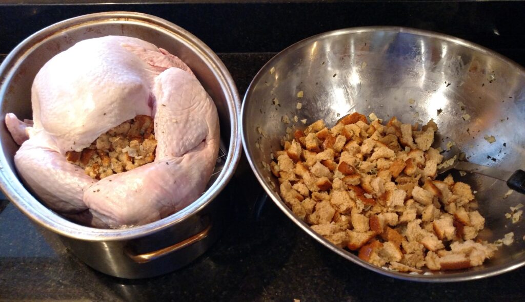 turkey with stuffing on left and bowl with uncooked stuffing on right