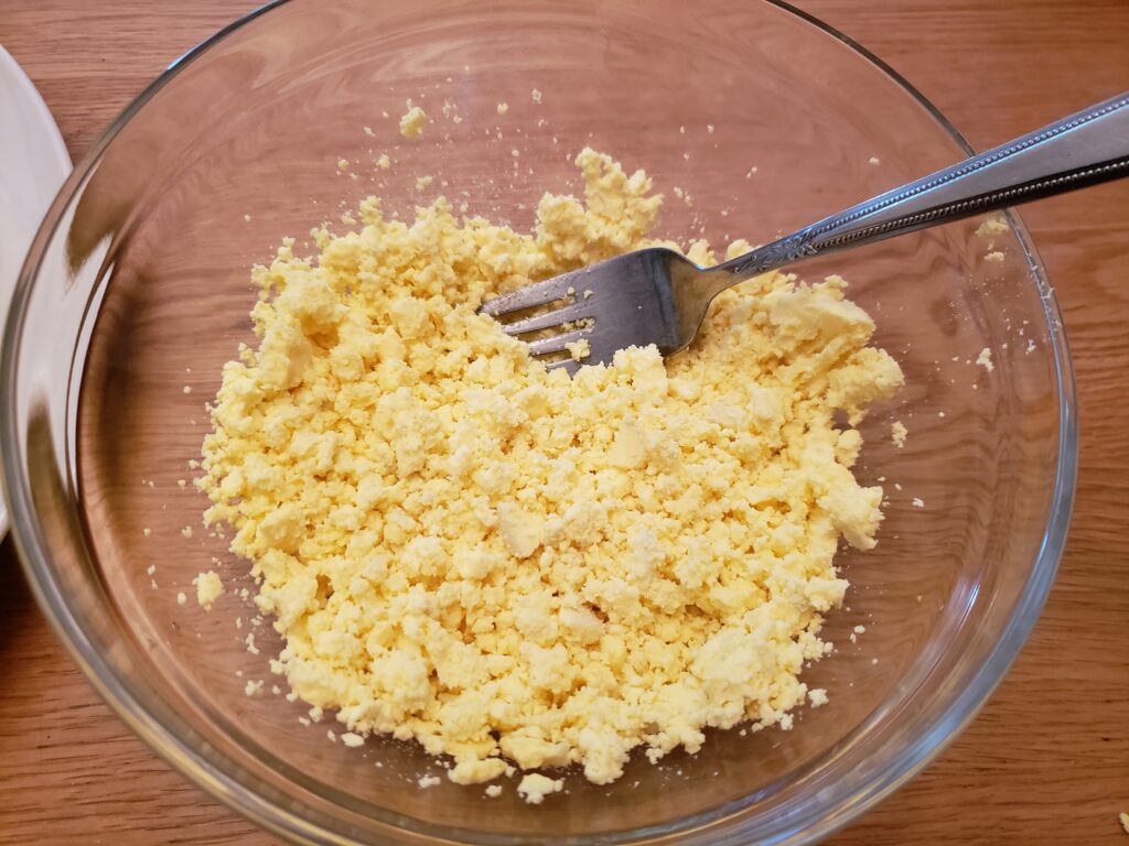 mashing the yolk in a bowl with a fork