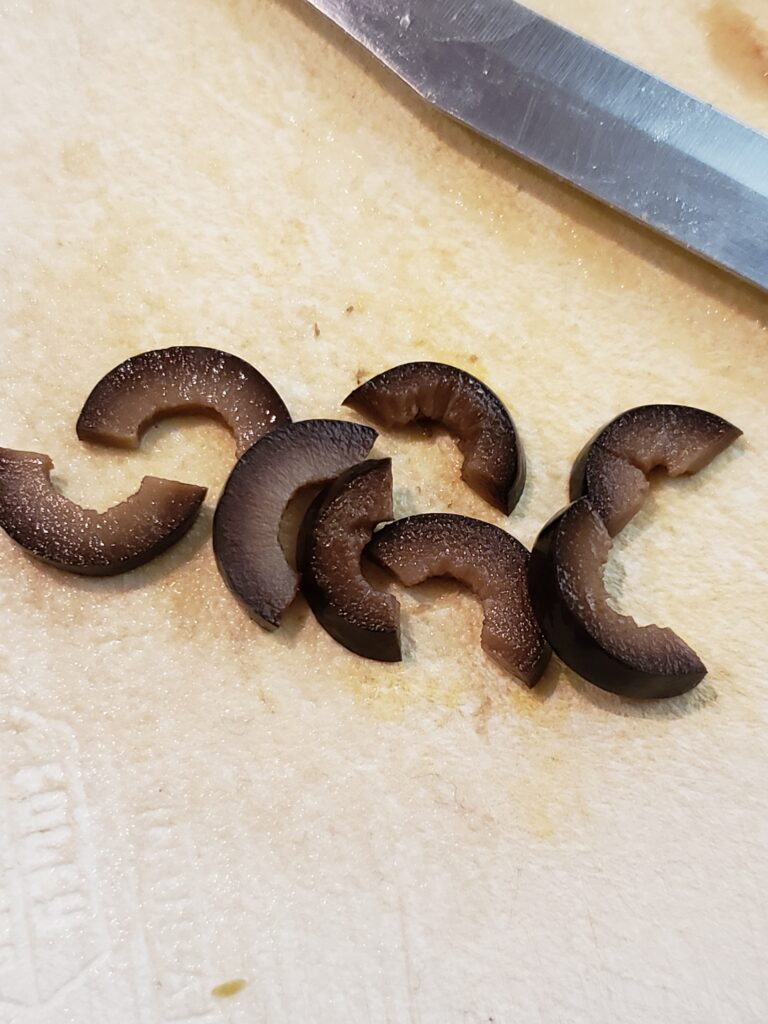 black olive halves sliced to be legs of spider.