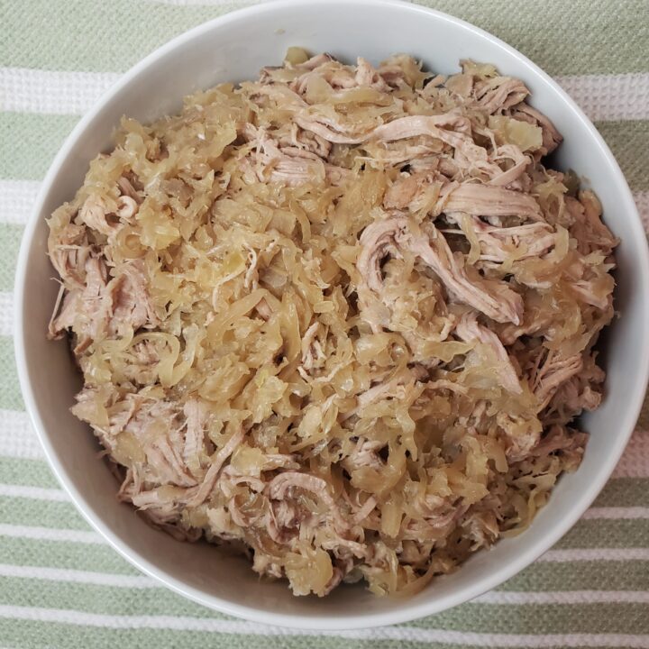 Slow Cooker Pork and Sauerkraut in white serving bowl