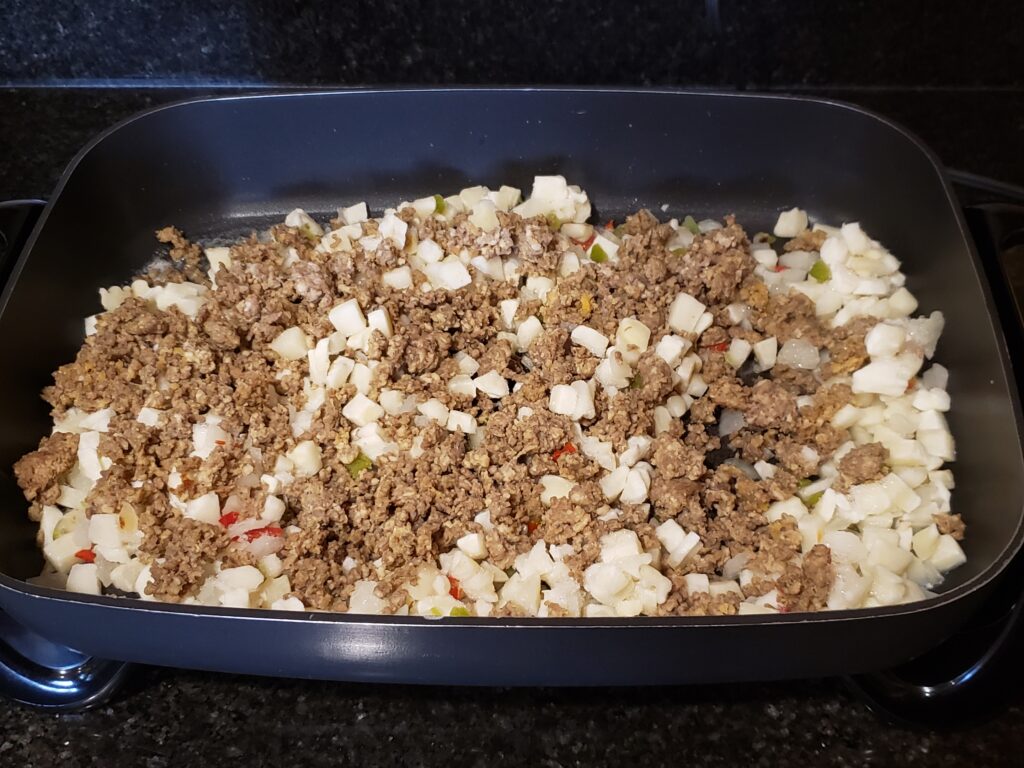 cooking sausage and ore ida potatoes in skillet