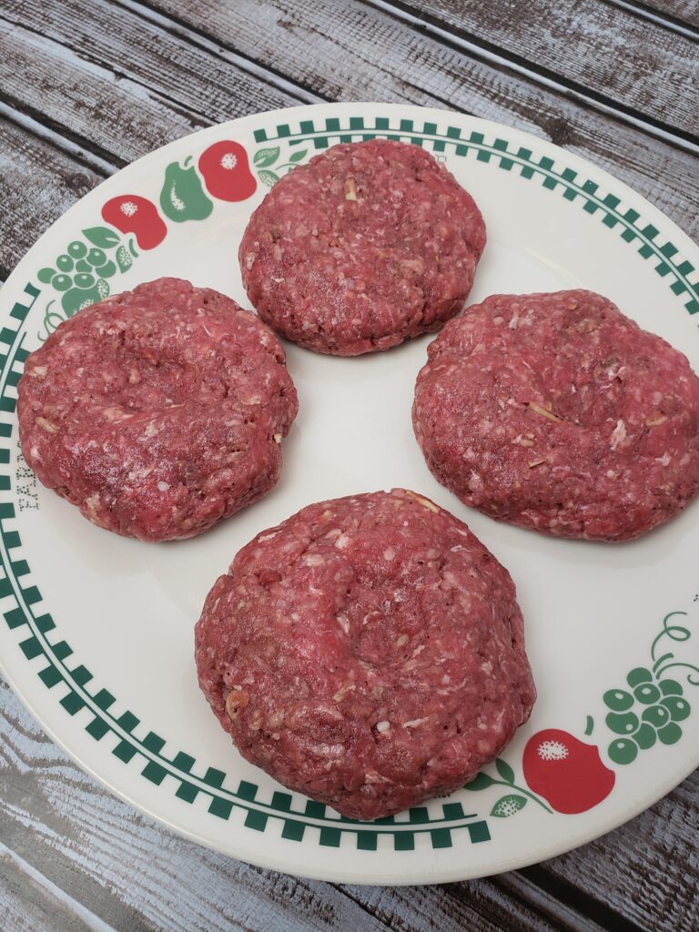 4 raw hamburger patties on a plate