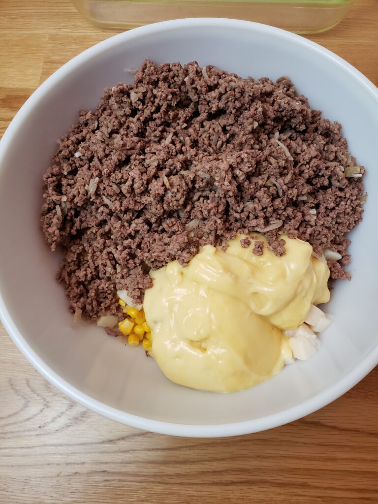 meat, cream of chicken soup, potatoes and corn in bowl