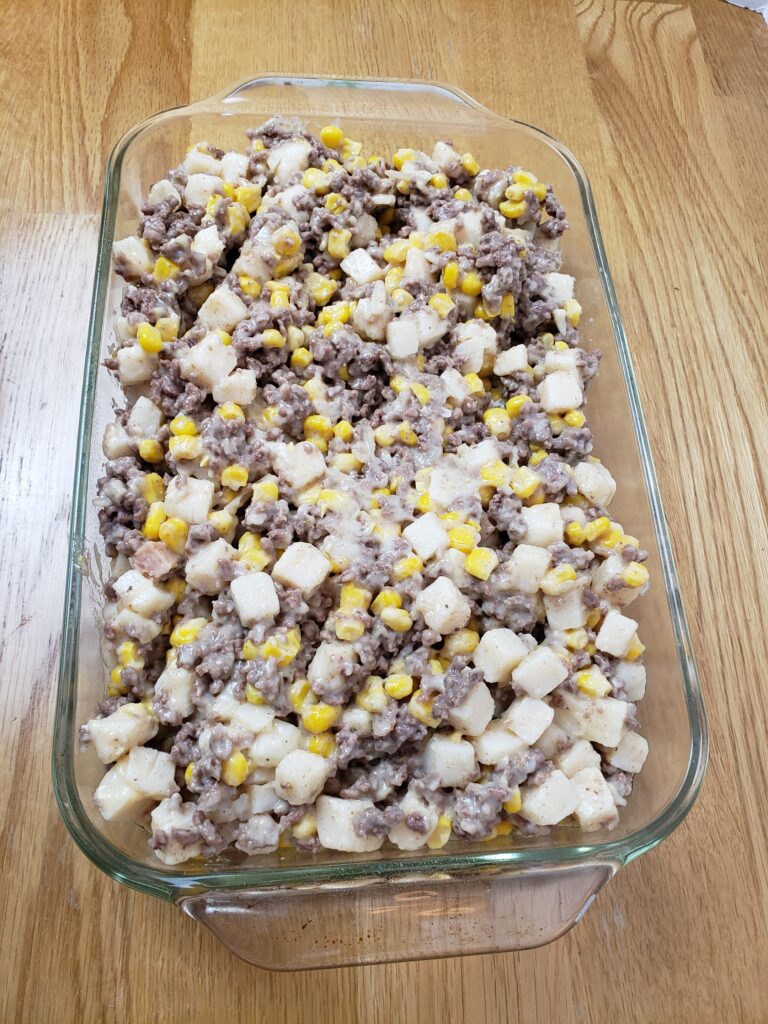 meat, cream of chicken soup, potatoes and corn added to casserole baking dish