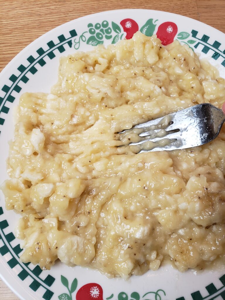 mashing bananas on plate with a fork