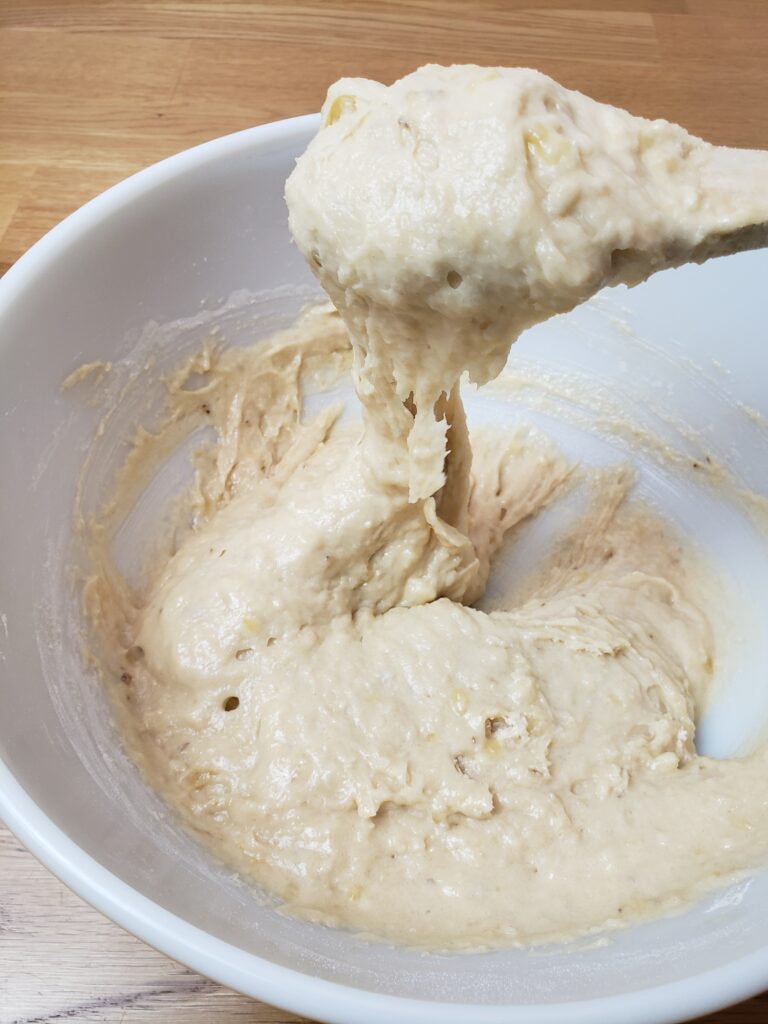 wooden spoon holding up some batter to show how thick it is