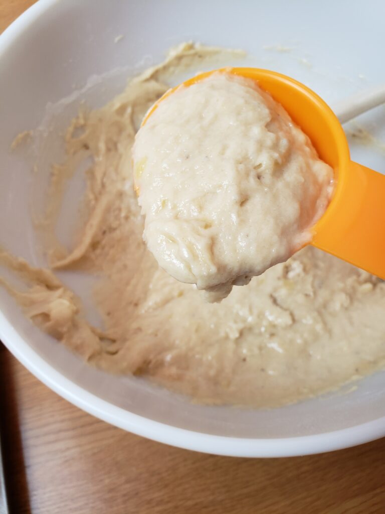 muffin batter in measuring cup to scoop into muffin pan