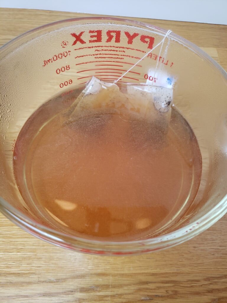 tea brewing in Pyrex glass measuring cup.