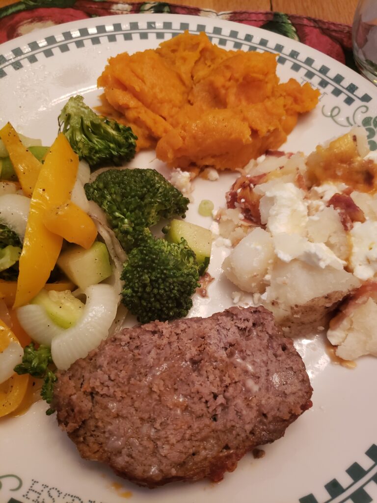 best gluten free low carb meatloaf, oven roasted vegetables, twice baked potatoes and sweet potatoes on a plate together