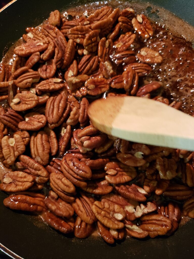 stirring pecans into sugar and butter mixture