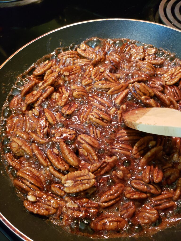 Candied Pecans simmering in skillet with sugar and butter mixture