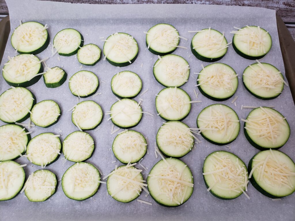 Cheesy Zucchini Coins on baking sheet ready to bake