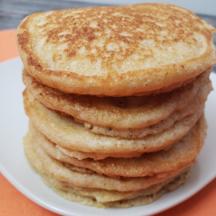 stack of 5 Multigrain Buttermilk Pancakes on a white plate.