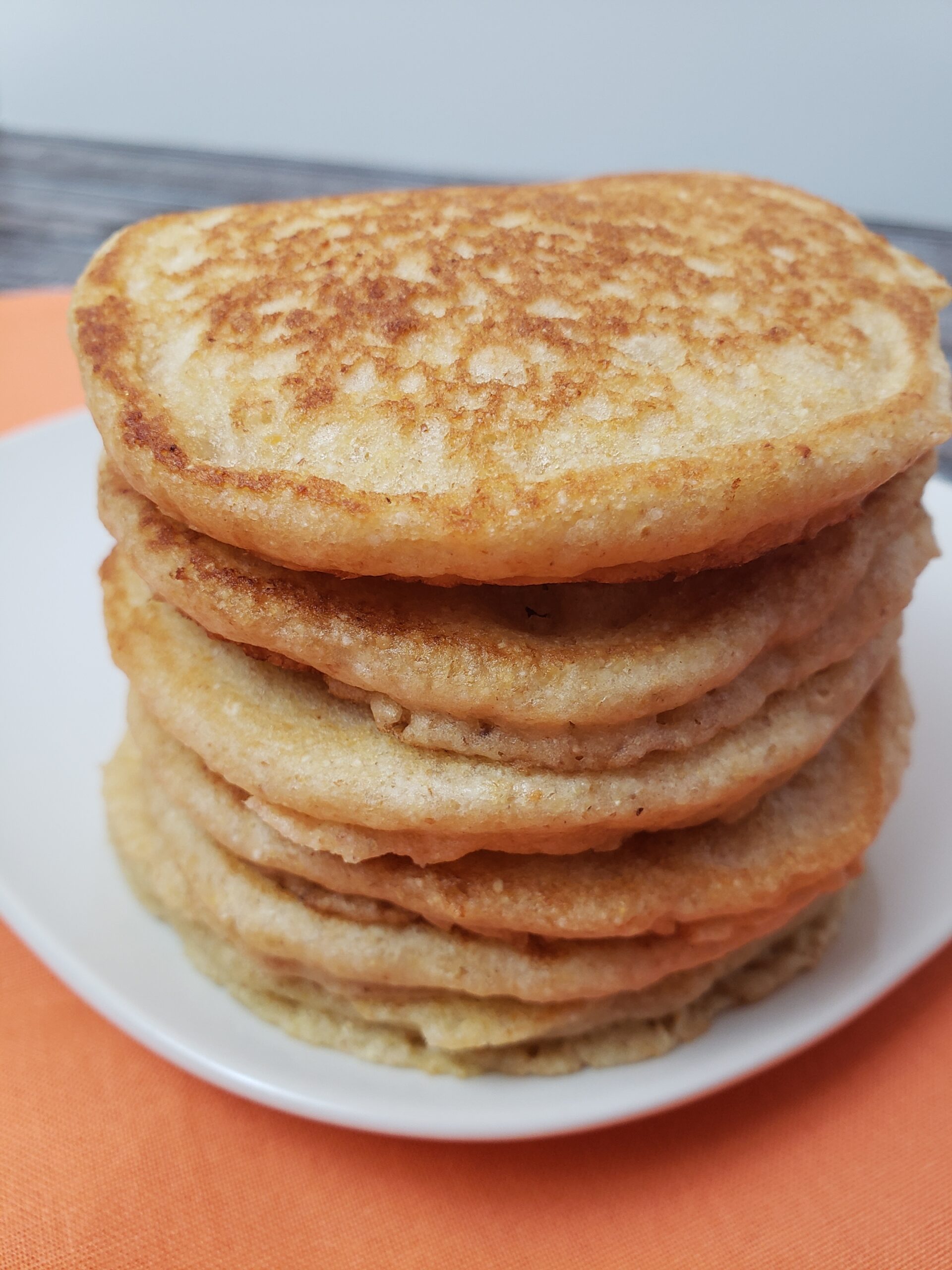 stack of 5 Multigrain Buttermilk Pancakes on a white plate.