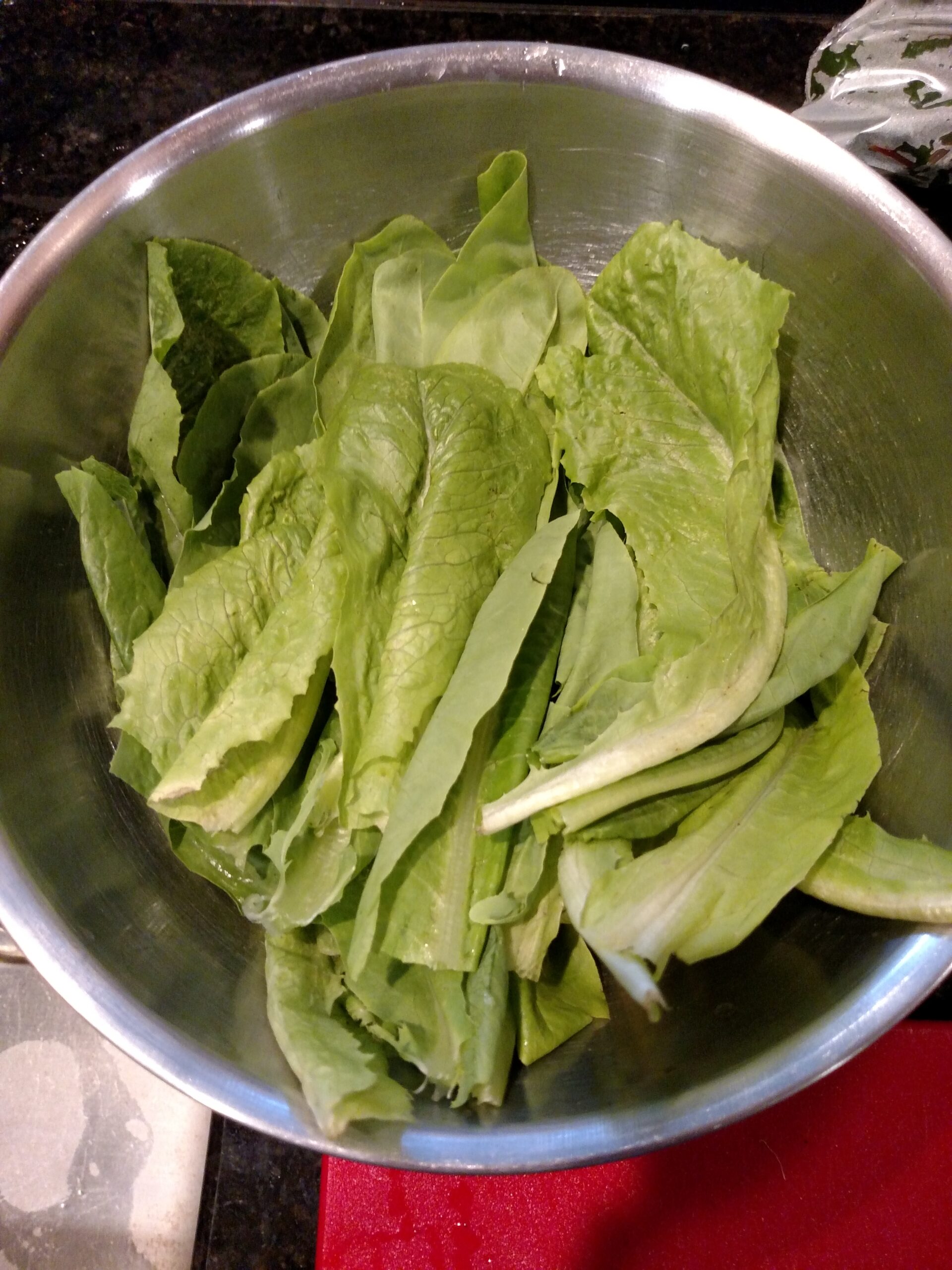 stainless steel bowl with fresh, garden lettuce in it.