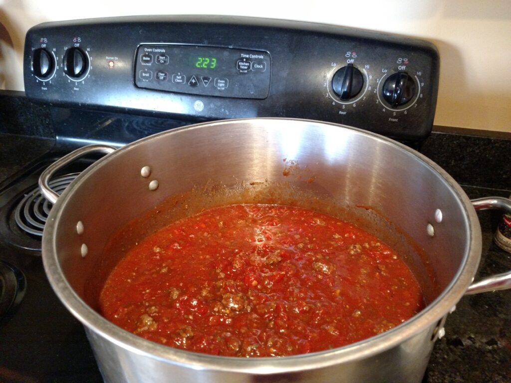 a big pot of pasta sauce on the stove