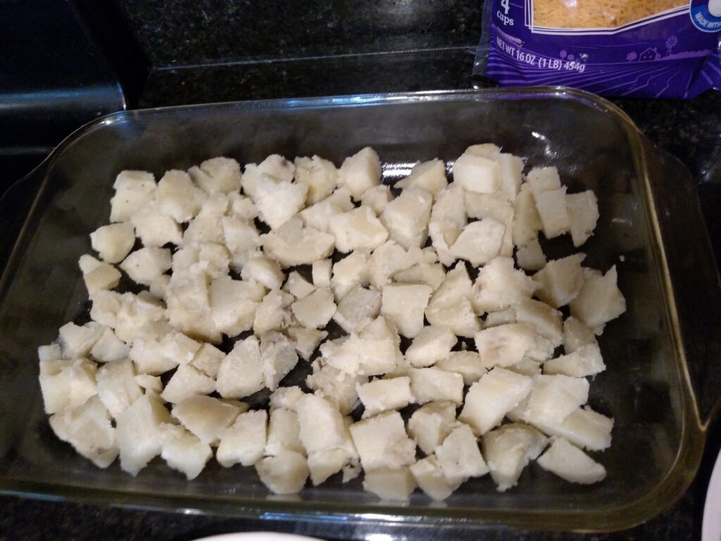 cubed of baked potato in casserole dish.