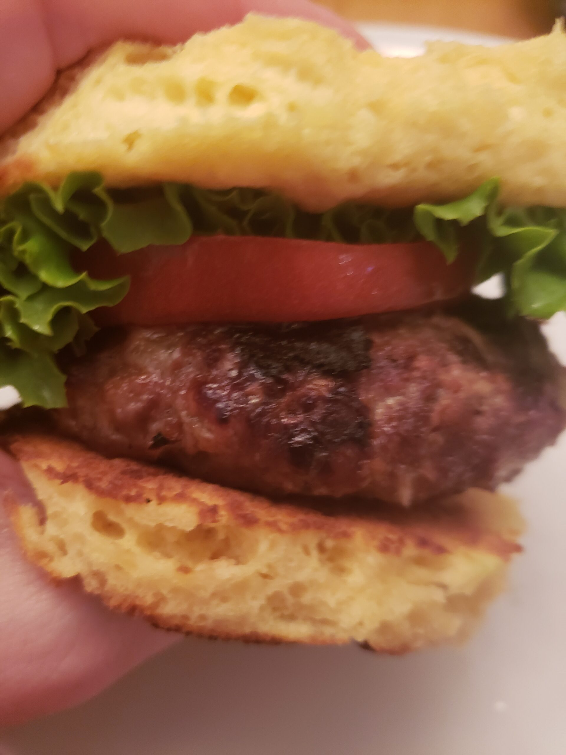 A Best Low Carb Burger in someone's hand ready to eat.