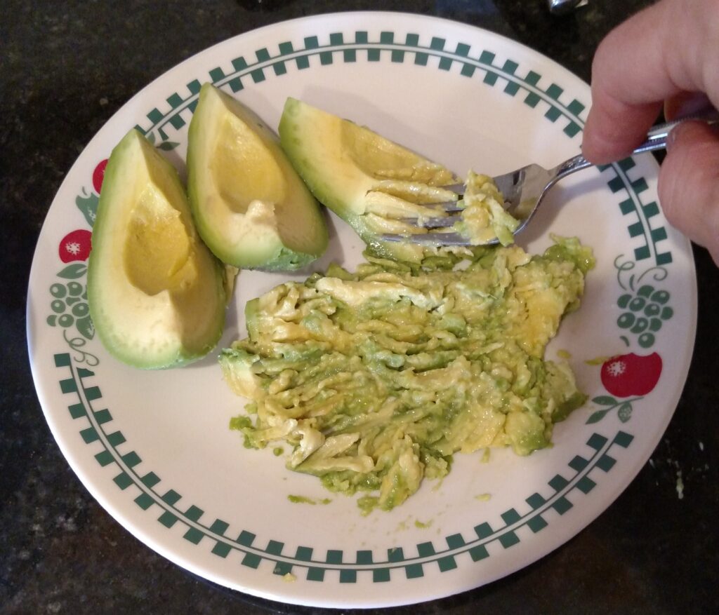 mashing avocado with fork