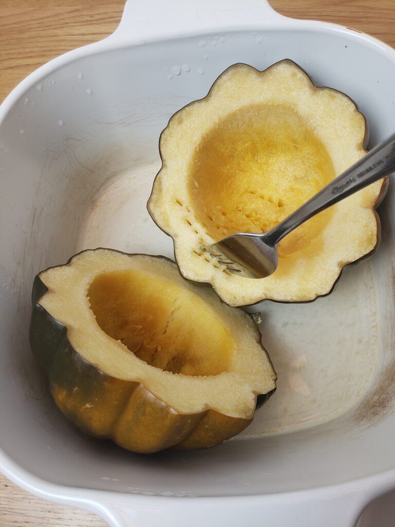 cooked acorn squash in slow cooker and poking it with a fork to test for doneness.