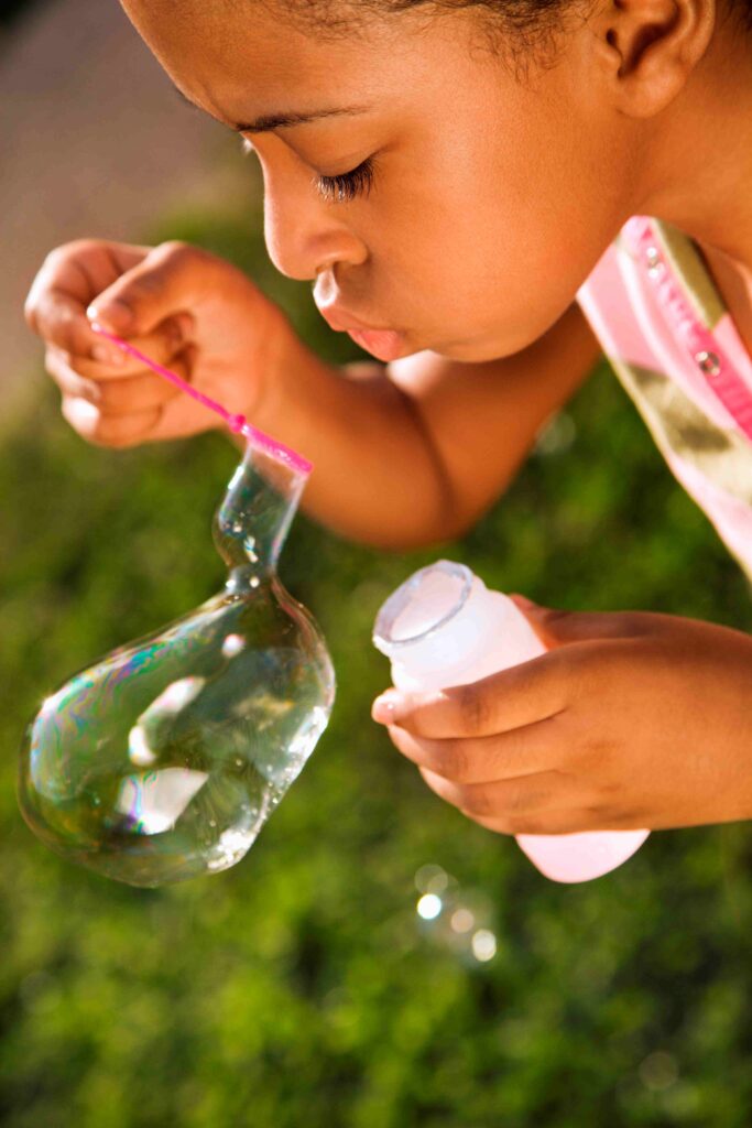 little girl blowing bubbles