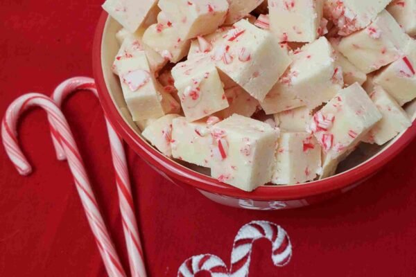 Peppermint Candy Cane Fudge peppermint candy cane fudge on red cloth in pretty bowl