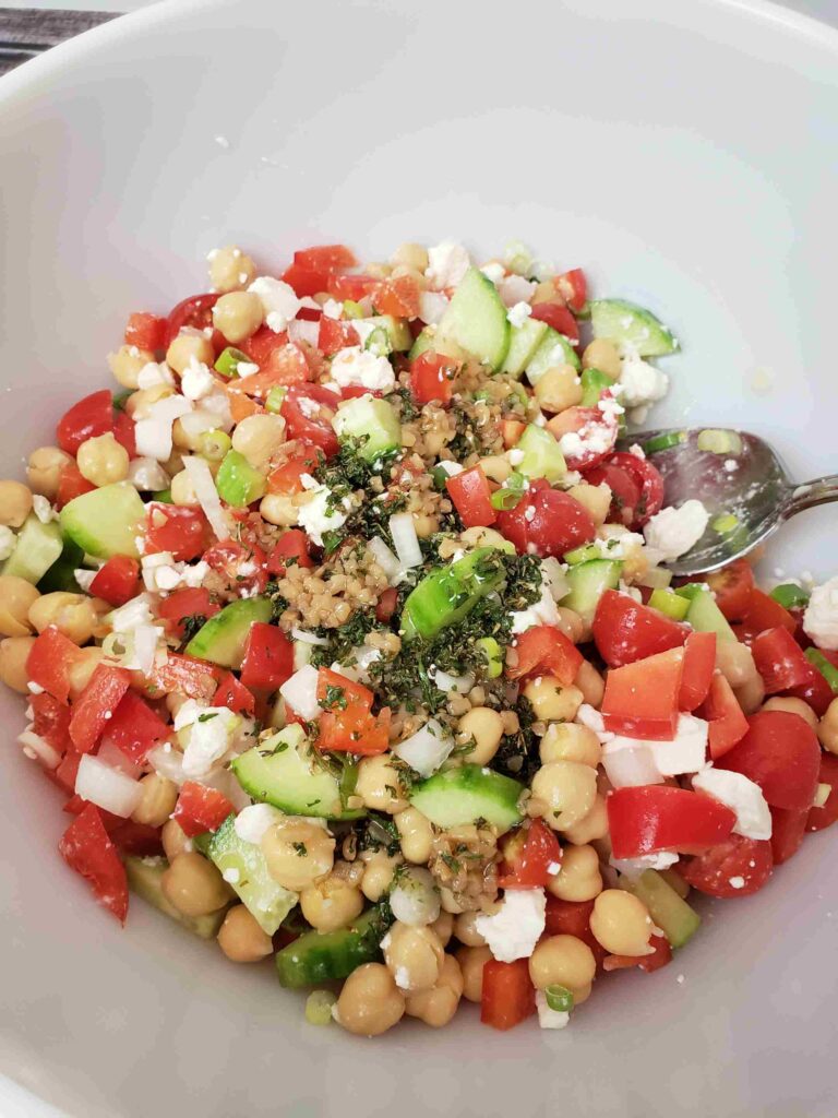 mixing chickpea salad together