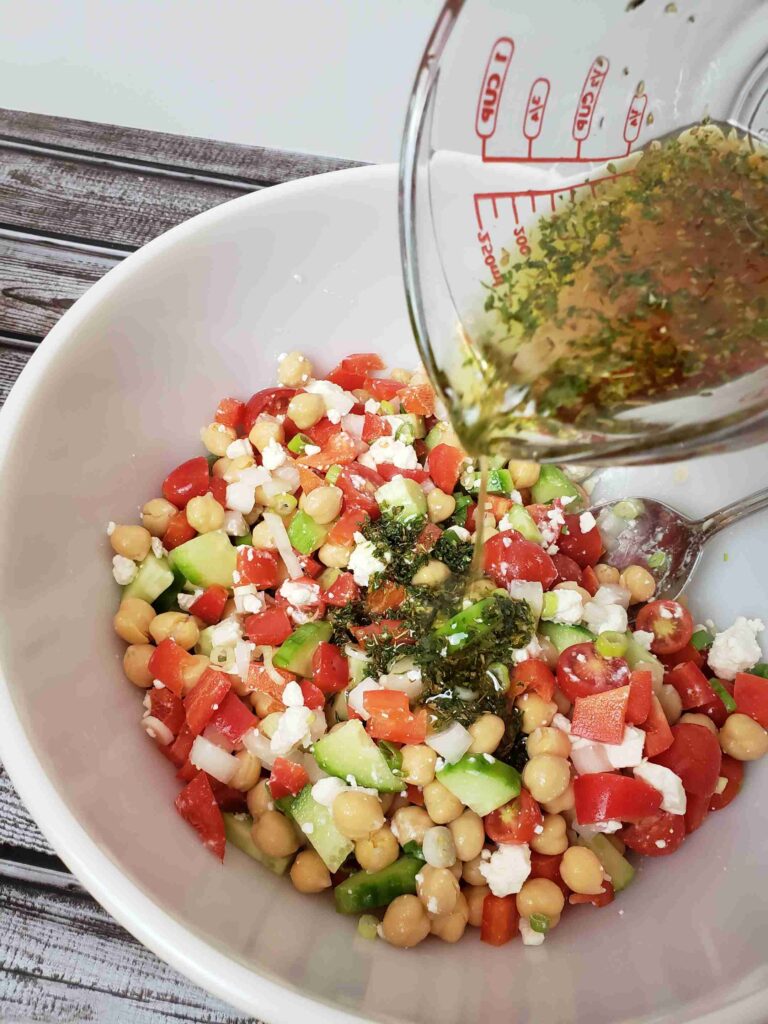 pouring dressing over salad