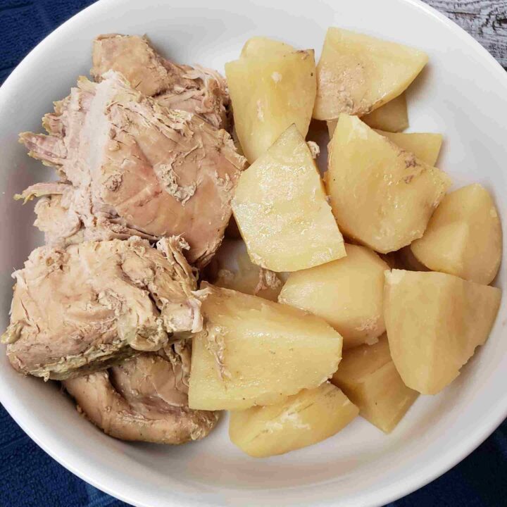slow cooker pork and potatoes in white serving dish